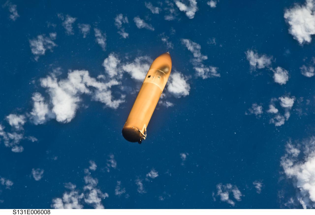S131-E-006008 (5 April 2010) --- Backdropped by a blue and white part of Earth, the STS-131 external fuel tank (ET) begins its relative separation from the Space Shuttle Discovery following launch.