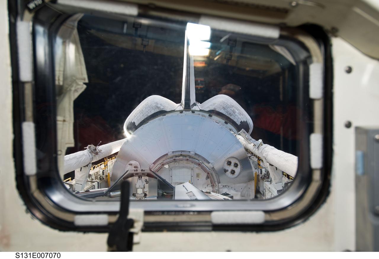 S131-E-007070 (5 April 2010) --- The Leonardo Multi-Purpose Logistics Module (MPLM) visible in space shuttle Discovery's payload bay, docking mechanism, vertical stabilizer, orbital maneuvering system (OMS) pods and Remote Manipulator System/Orbiter Boom Sensor System (RMS/OBSS) are featured in this image photographed by an STS-131 crew member from an aft flight deck window.