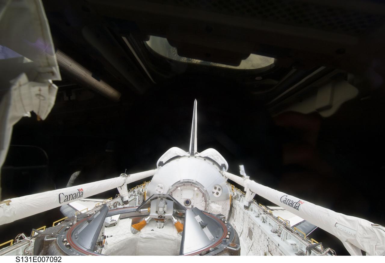 S131-E-007092 (5 April 2010) --- The Leonardo Multi-Purpose Logistics Module (MPLM) visible in space shuttle Discovery's payload bay, docking mechanism, vertical stabilizer, orbital maneuvering system (OMS) pods and Remote Manipulator System/Orbiter Boom Sensor System (RMS/OBSS) are featured in this image photographed by an STS-131 crew member from an aft flight deck window.