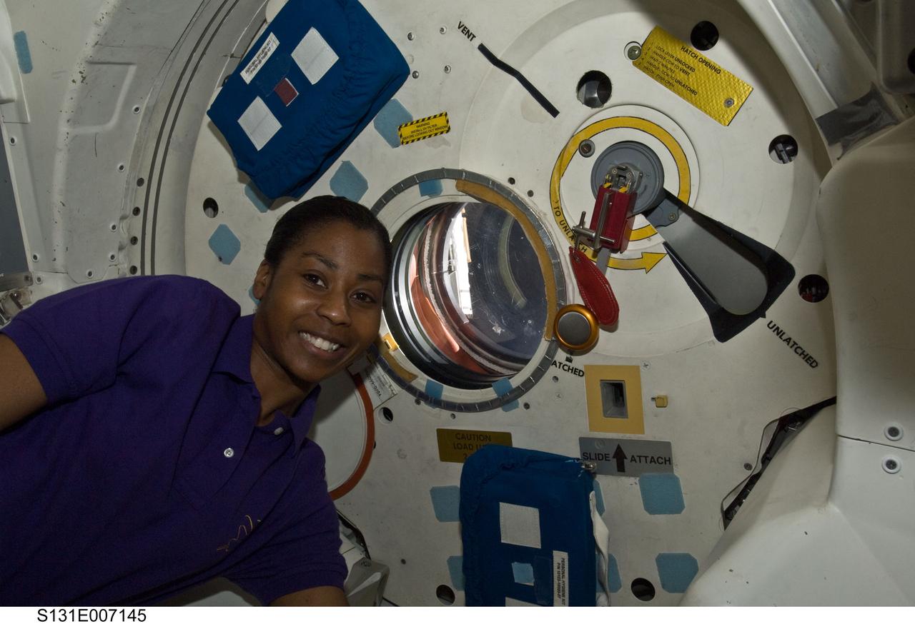 S131-E-007145 (6 April 2010) --- NASA astronaut Stephanie Wilson, STS-131 mission specialist, is pictured near a hatch window on the middeck of space shuttle Discovery during flight day two activities.