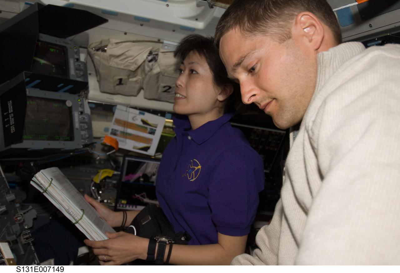 S131-E-007149 (6 April 2010) --- NASA astronaut James P. Dutton Jr., STS-131 pilot; and Japan Aerospace Exploration Agency (JAXA) astronaut Naoko Yamazaki, mission specialist, work on the aft flight deck of space shuttle Discovery during flight day two activities.