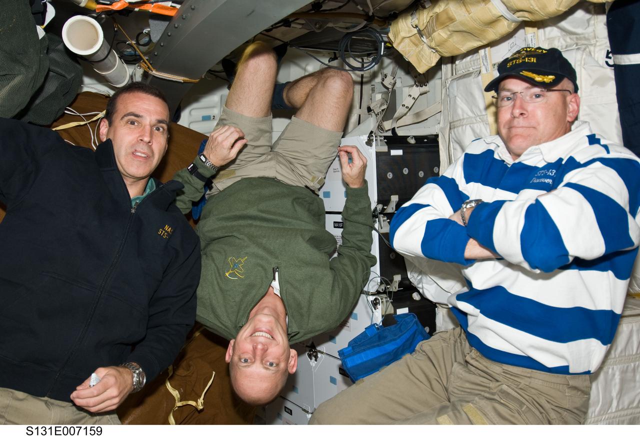 S131-E-007159 (6 April 2010) --- NASA astronaut Alan Poindexter (right), STS-131 commander; along with astronauts Clayton Anderson (center) and Rick Mastracchio, both mission specialists, are pictured on the middeck deck of space shuttle Discovery during flight day two activities.