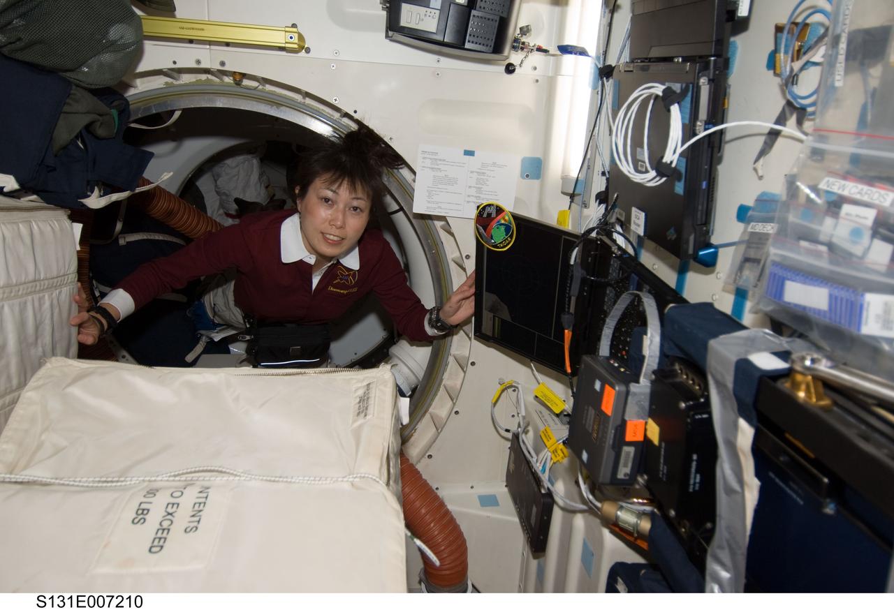S131-E-007210 (6 April 2010) --- Japan Aerospace Exploration Agency (JAXA) astronaut Naoko Yamazaki, STS-131 mission specialist, floats through a hatch on the middeck of space shuttle Discovery during flight day three activities.
