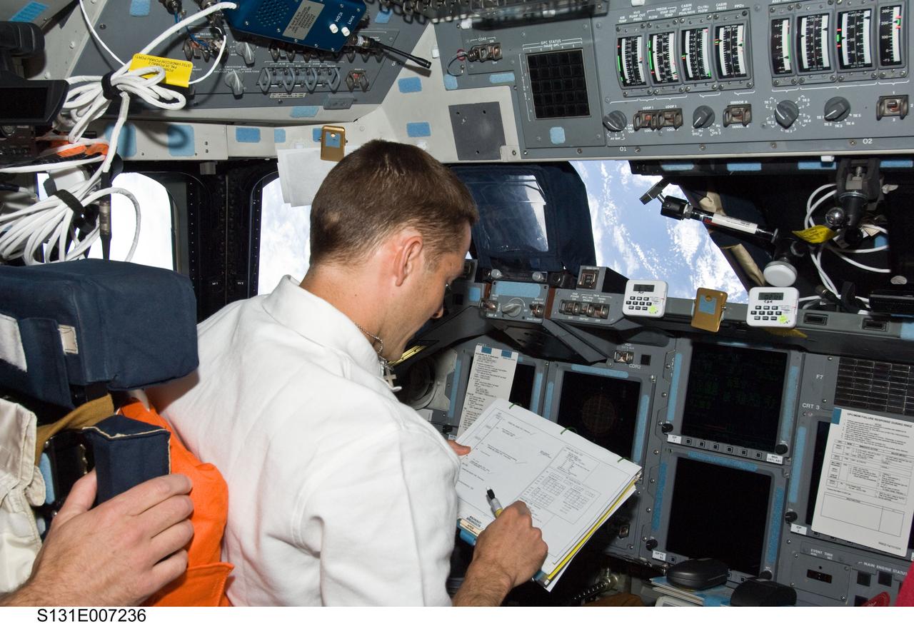 S131-E-007236 (7 April 2010) --- NASA astronaut James P. Dutton Jr., STS-131 pilot, occupies the commander?s station on the forward flight deck of space shuttle Discovery during flight day three activities.
