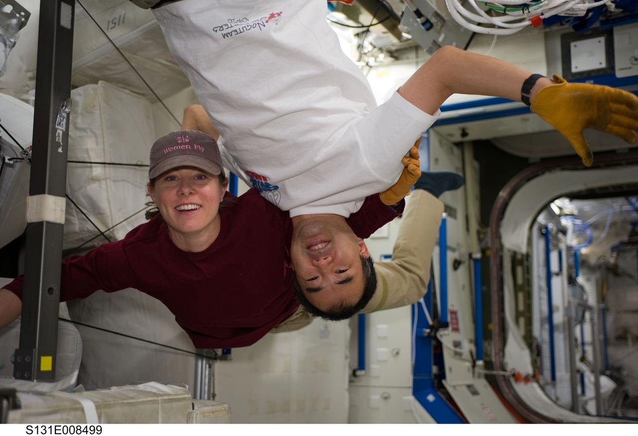 S131-E-008499 (10 April 2010) --- NASA astronaut Tracy Caldwell Dyson and Japan Aerospace Exploration Agency (JAXA) astronaut Soichi Noguchi, both Expedition 23 flight engineers, pose for a photo in the Destiny laboratory of the International Space Station while space shuttle Discovery (STS-131) remains docked with the station.