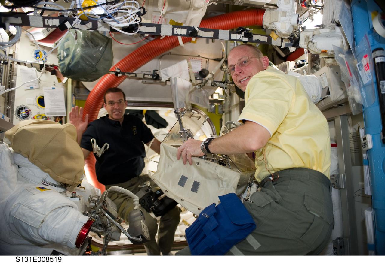 S131-E-008519 (10 April 2010) --- NASA astronauts Rick Mastracchio (left) and Clayton Anderson, both STS-131 mission specialists, work in the Quest airlock of the International Space Station while space shuttle Discovery remains docked with the station.