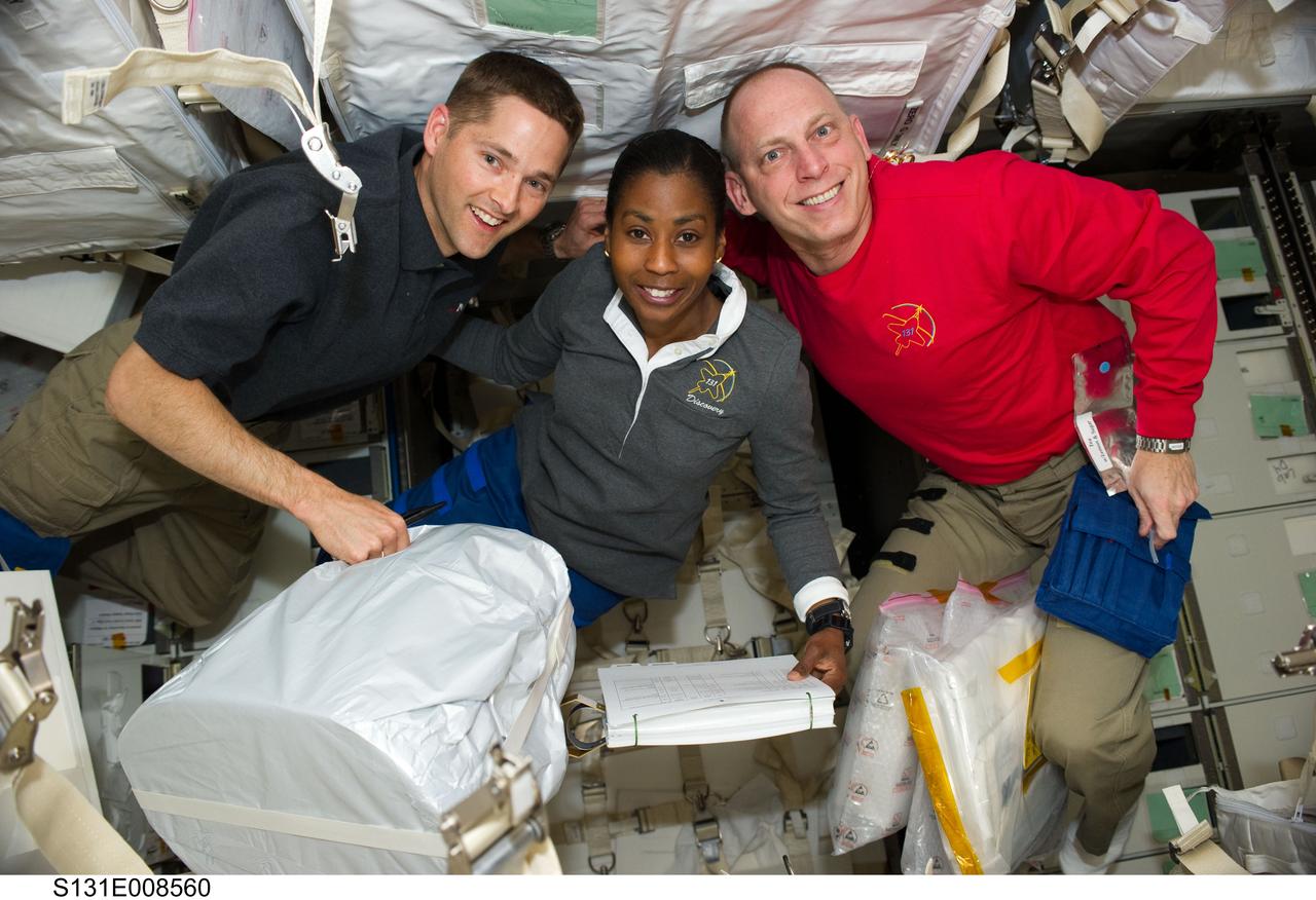 S131-E-008560 (10 April 2010) --- NASA astronauts James P. Dutton Jr. (left), STS-131 pilot; Stephanie Wilson and Clayton Anderson, both mission specialists, pose for a photo in the Leonardo Multi-Purpose Logistics Module (MPLM) linked to the International Space Station while space shuttle Discovery remains docked with the station.