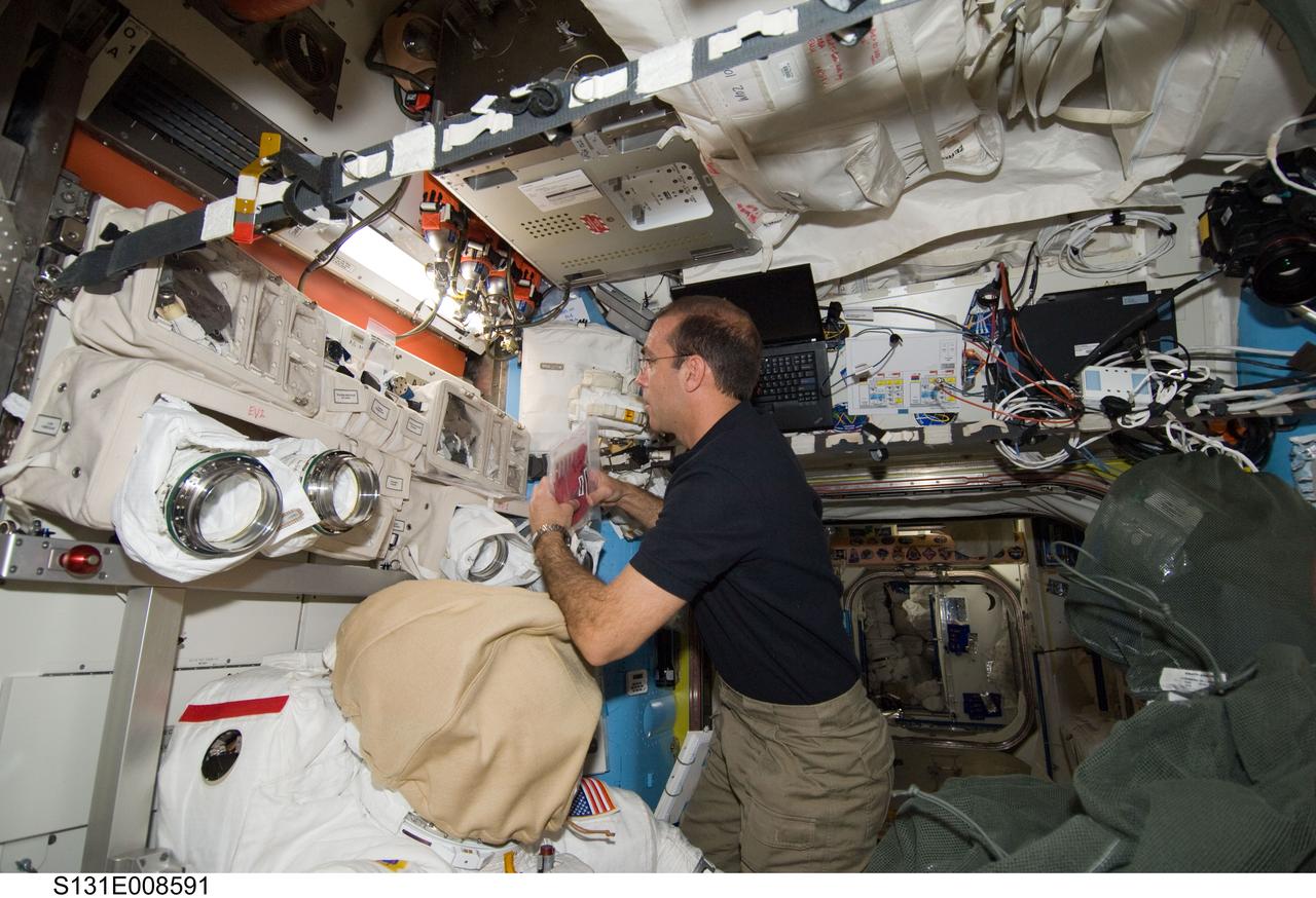 S131-E-008591 (10 April 2010) --- NASA astronaut Rick Mastracchio, STS-131 mission specialist, works in the Quest airlock of the International Space Station while space shuttle Discovery remains docked with the station.