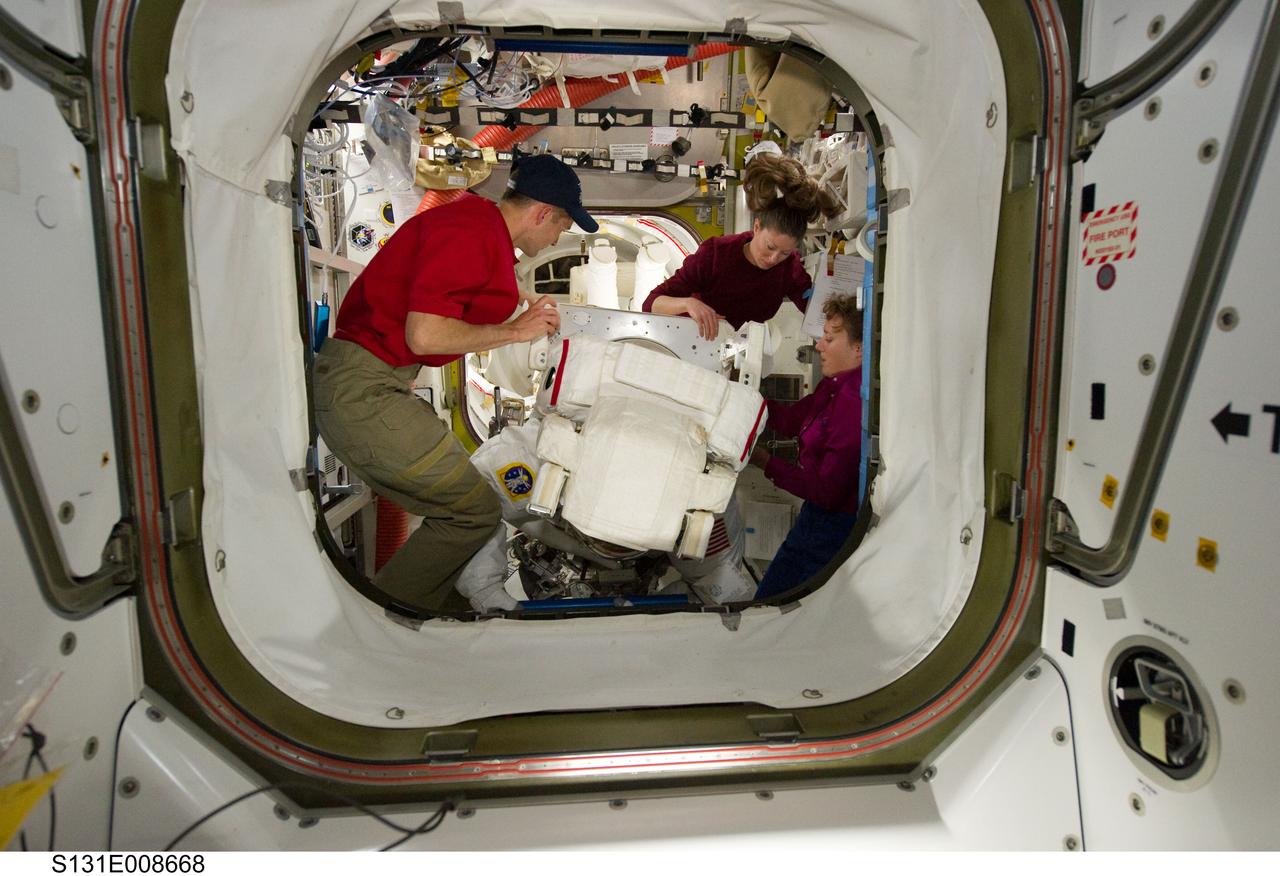 S131-E-008668 (11 April 2010) --- NASA astronauts James P. Dutton Jr., STS-131 pilot; Tracy Caldwell Dyson (second right), Expedition 23 flight engineer; and Dorothy Metcalf-Lindenburger, mission specialist, assist astronaut Rick Mastracchio, mission specialist, with his Extravehicular Mobility Unit (EMU) spacesuit in the Quest airlock of the International Space Station in preparation for the start of the mission's second spacewalk.