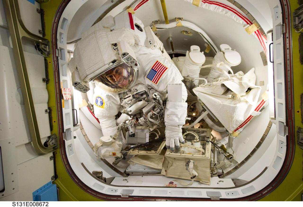 S131-E-008672 (11 April 2010) --- NASA astronauts Rick Mastracchio (left) and Clayton Anderson, both STS-131 mission specialists, attired in their Extravehicular Mobility Unit (EMU) spacesuits, prepare to exit the Quest airlock of the International Space Station to begin the mission's second spacewalk.