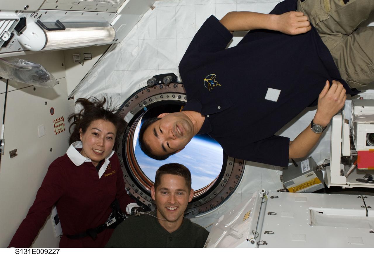 S131-E-009227 (12 April 2010) --- Japan Aerospace Exploration Agency (JAXA) astronauts Naoko Yamazaki (left), STS-131 mission specialist; and Soichi Noguchi, Expedition 23 flight engineer; along with NASA astronaut James P. Dutton Jr. (bottom), STS-131 pilot, pose for a photo near a window in the Kibo laboratory of the International Space Station while space shuttle Discovery remains docked with the station.