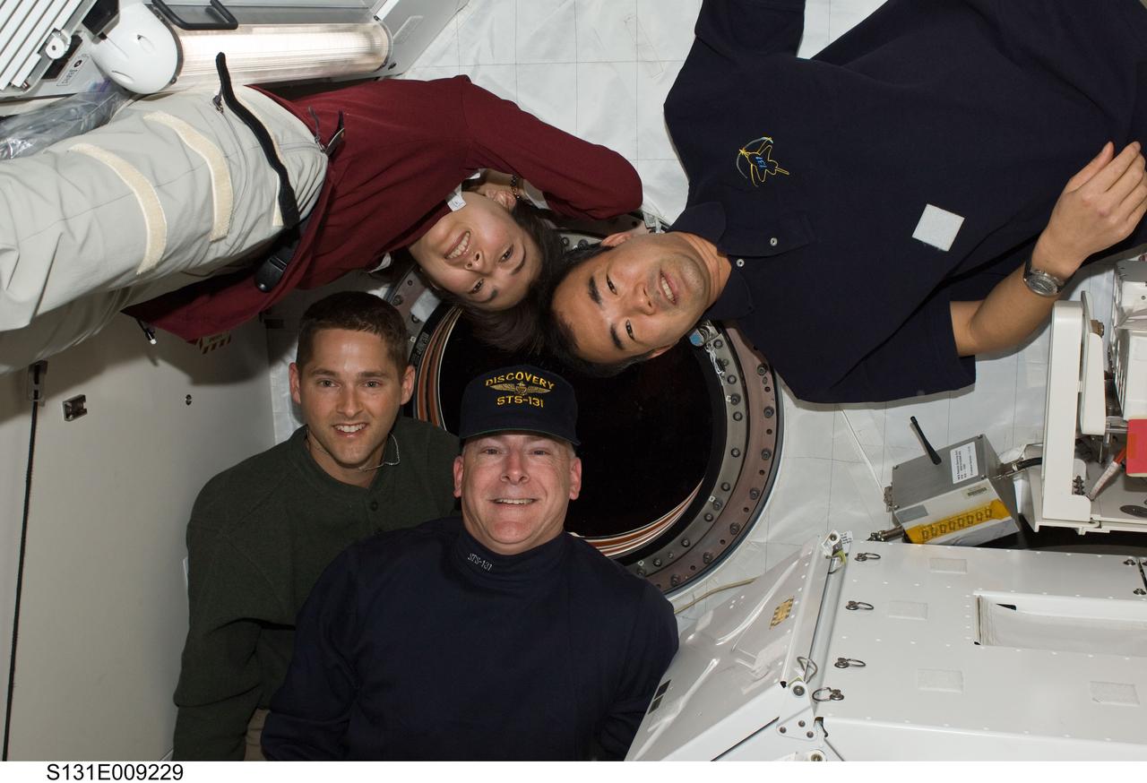 S131-E-009229 (12 April 2010) --- NASA astronauts Alan Poindexter (bottom right) and James P. Dutton Jr. (bottom left), STS-131 commander and pilot, respectively; along with Japan Aerospace Exploration Agency (JAXA) astronauts Naoko Yamazaki (upper left), STS-131 mission specialist; and Soichi Noguchi, Expedition 23 flight engineer, pose for a photo near a window in the Kibo laboratory of the International Space Station while space shuttle Discovery remains docked with the station.
