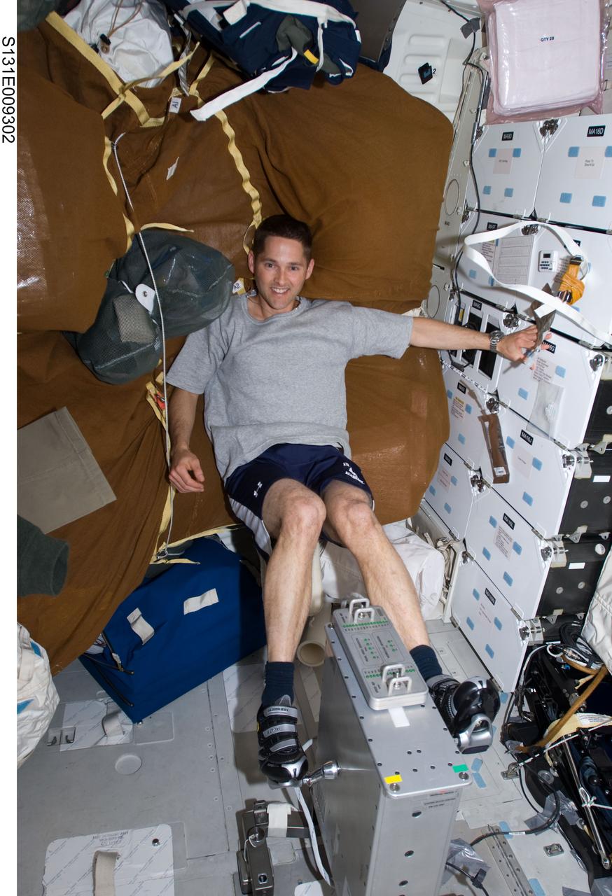 S131-E-009302 (12 April 2010) --- NASA astronaut James P. Dutton Jr., STS-131 pilot, exercises on a bicycle ergometer on the middeck of space shuttle Discovery while docked with the International Space Station.