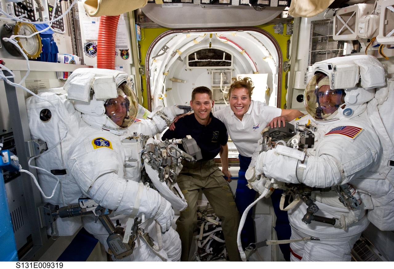 S131-E-009319 (13 April 2010) --- NASA astronauts Clayton Anderson (left) and Rick Mastracchio, both STS-131 mission specialists, attired in their Extravehicular Mobility Unit (EMU) spacesuits; along with astronauts James P. Dutton Jr., pilot; and Dorothy Metcalf-Lindenburger, mission specialist, pose for a photo in the Quest airlock of the International Space Station prior to the start of the mission's third and final spacewalk.