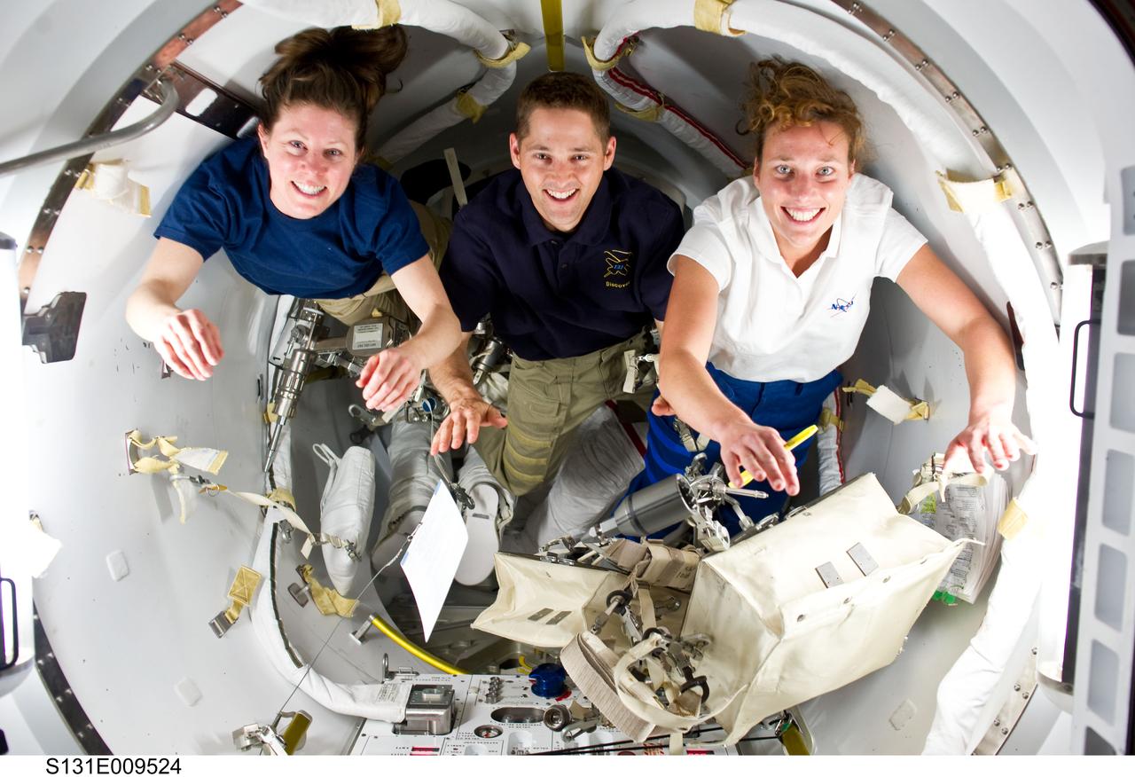 S131-E-009524 (13 April 2010) --- NASA astronauts James P. Dutton Jr., STS-131 pilot; Tracy Caldwell Dyson (left), Expedition 23 flight engineer; and Dorothy Metcalf-Lindenburger, STS-131 mission specialist, take a brief moment to pose for a photo in the Quest airlock of the International Space Station while space shuttle Discovery remains docked with the station. Astronauts Rick Mastracchio and Clayton Anderson (out of frame) had just completed the mission’s third and final spacewalk.