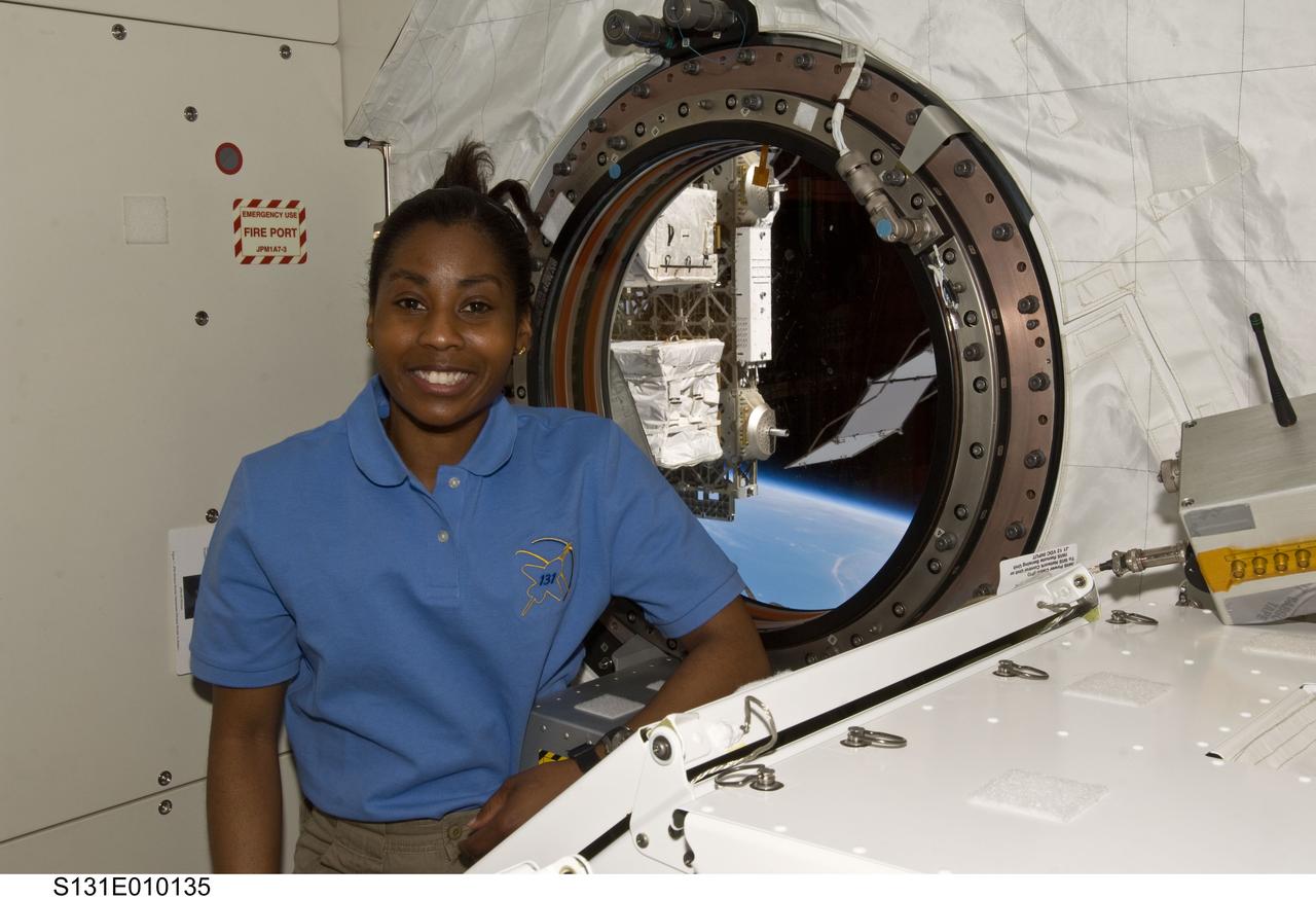 S131-E-010135 (14 April 2010) --- NASA astronaut Stephanie Wilson, STS-131 mission specialist, poses for a photo near a window in the Kibo laboratory of the International Space Station while space shuttle Discovery remains docked with the station.