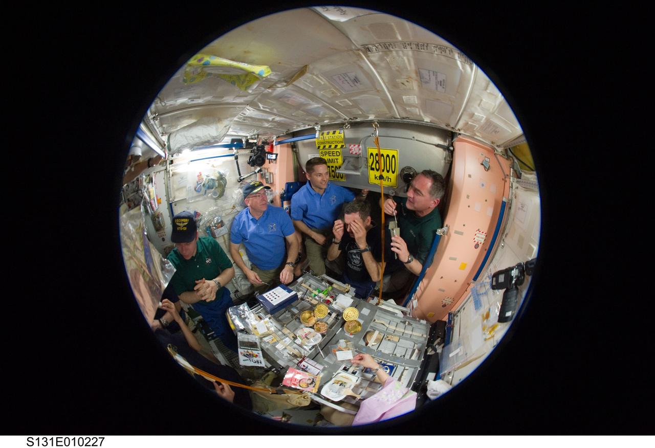 S131-E-010227 (14 April 2010) --- A fish-eye lens attached to an electronic still camera was used to capture this image of STS-131 and Expedition 23 crew members as they share a meal in the Unity node of the International Space Station while space shuttle Discovery remains docked with the station. Pictured are NASA astronauts Alan Poindexter, James P. Dutton Jr.; and Russian cosmonauts Oleg Kotov, Mikhail Kornienko and Alexander Skvortsov.