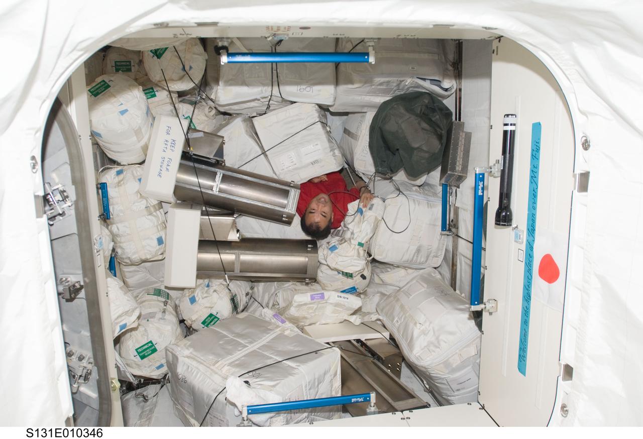 S131-E-010346 (16 April 2010) --- Japan Aerospace Exploration Agency (JAXA) astronaut Soichi Noguchi, Expedition 23 flight engineer, works among stowage containers in the Japanese Logistics Module - Pressurized Section (JLP) of the International Space Station while space shuttle Discovery (STS-131) remains docked with the station.