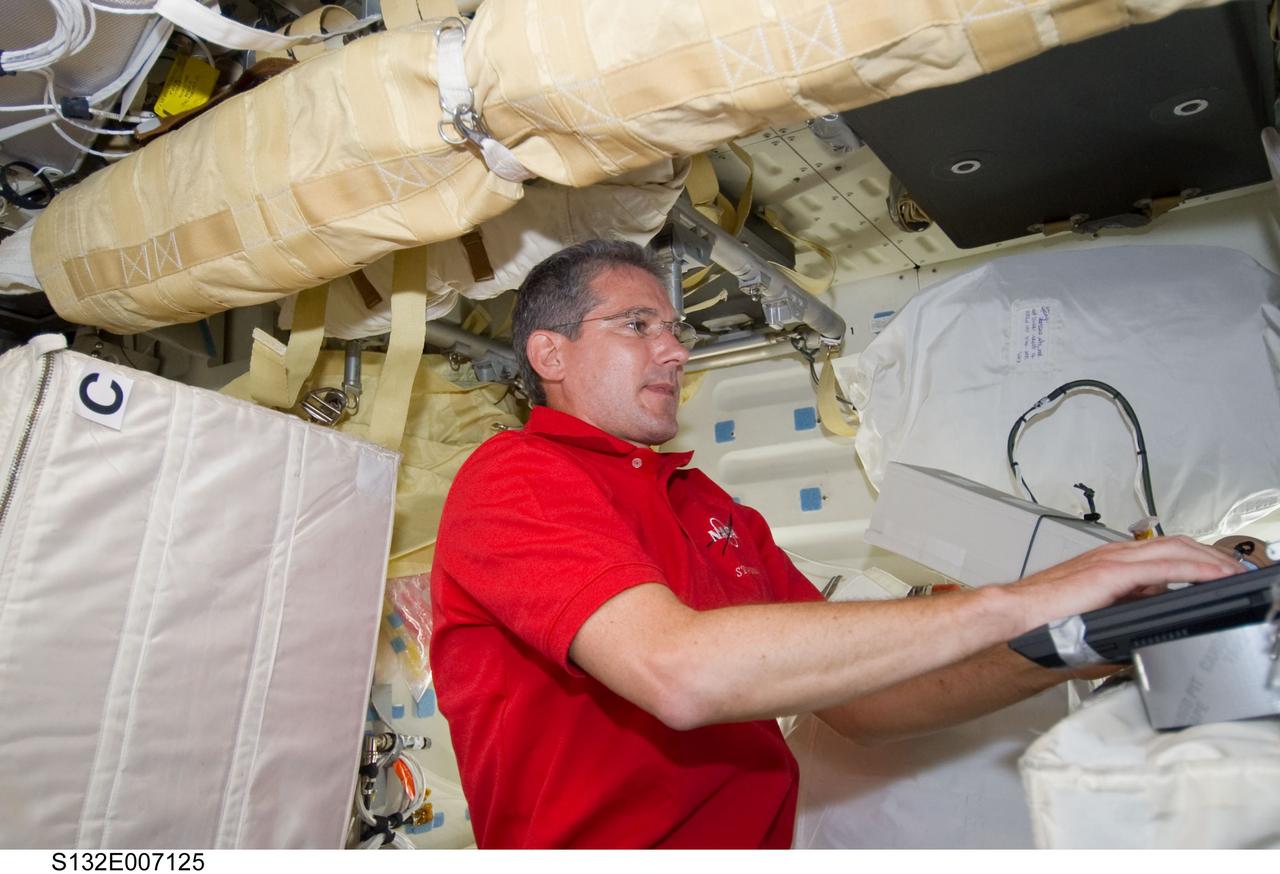 S132-E-007125 (15 May 2010) --- NASA astronaut Michael Good, STS-132 mission specialist, uses a computer on the middeck of the Earth-orbiting space shuttle Atlantis during flight day two activities.