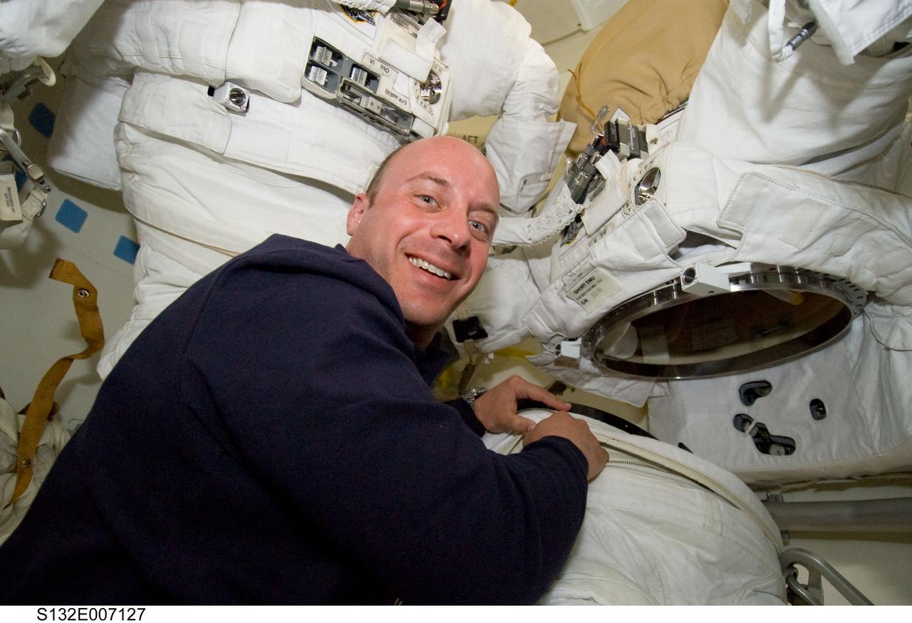 S132-E-007127 (15 May 2010) --- NASA astronaut Garrett Reisman, STS-132 mission specialist, works with an Extravehicular Mobility Unit (EMU) spacesuit on the middeck of the Earth-orbiting space shuttle Atlantis during flight day two activities.