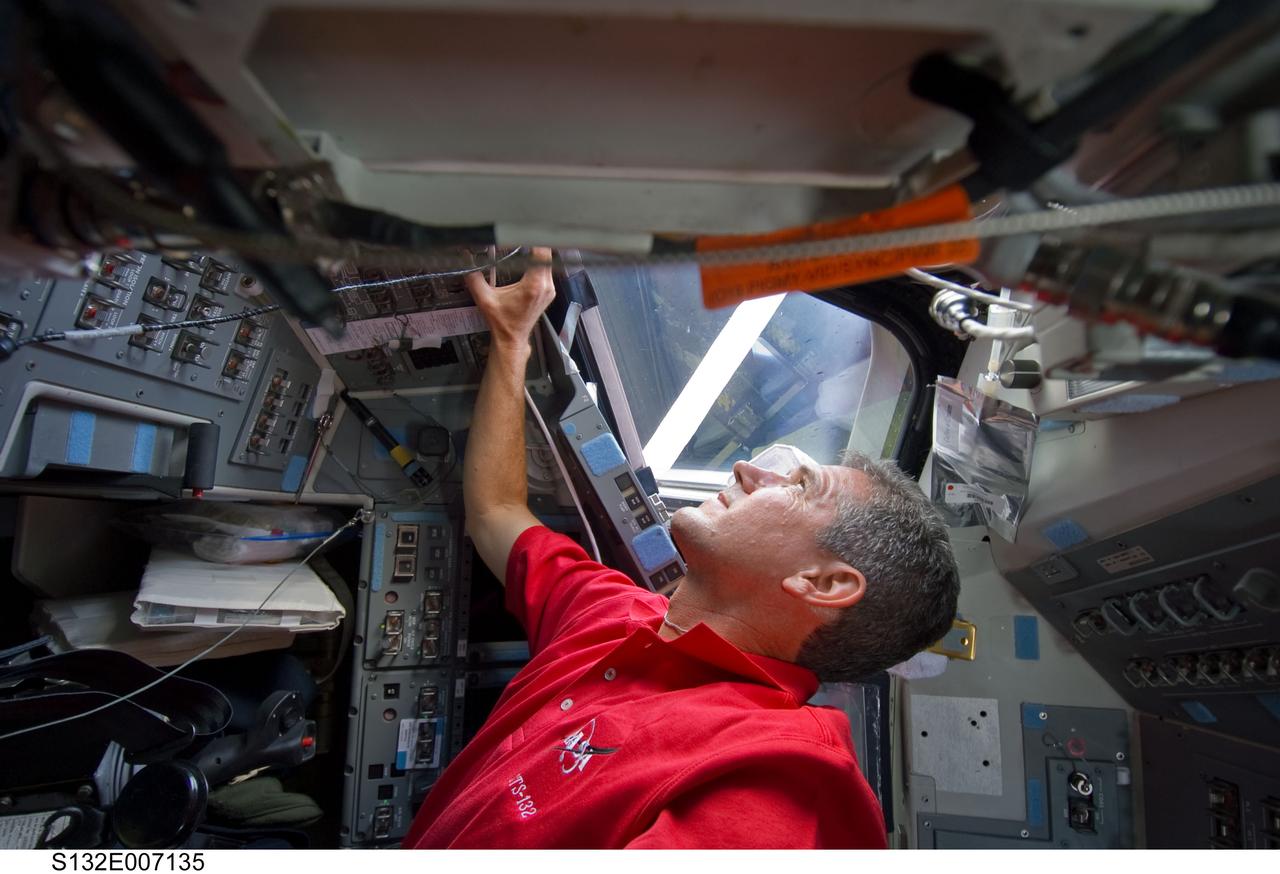 S132-E-007135 (15 May 2010) --- NASA astronaut Michael Good, STS-132 mission specialist, looks through a window on the flight deck of the Earth-orbiting space shuttle Atlantis during flight day two activities.