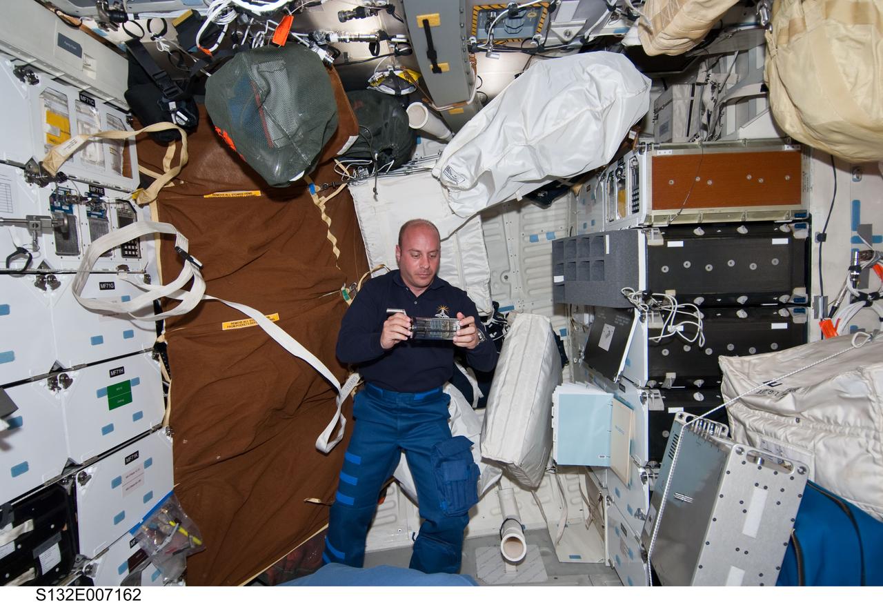 S132-E-007162 (15 May 2010) --- NASA astronaut Garrett Reisman, STS-132 mission specialist, works with a sample from Group Activation Packs (GAP) on the middeck of space shuttle Atlantis during Flight Day 2 activities. Photo credit: National Aeronautics and Space Administration