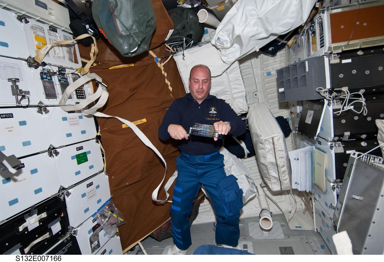 S132-E-007166 (15 May 2010) --- NASA astronaut Garrett Reisman, STS-132 mission specialist, works with a sample from Group Activation Packs (GAP) on the middeck of space shuttle Atlantis during Flight Day 2 activities. Photo credit: National Aeronautics and Space Administration