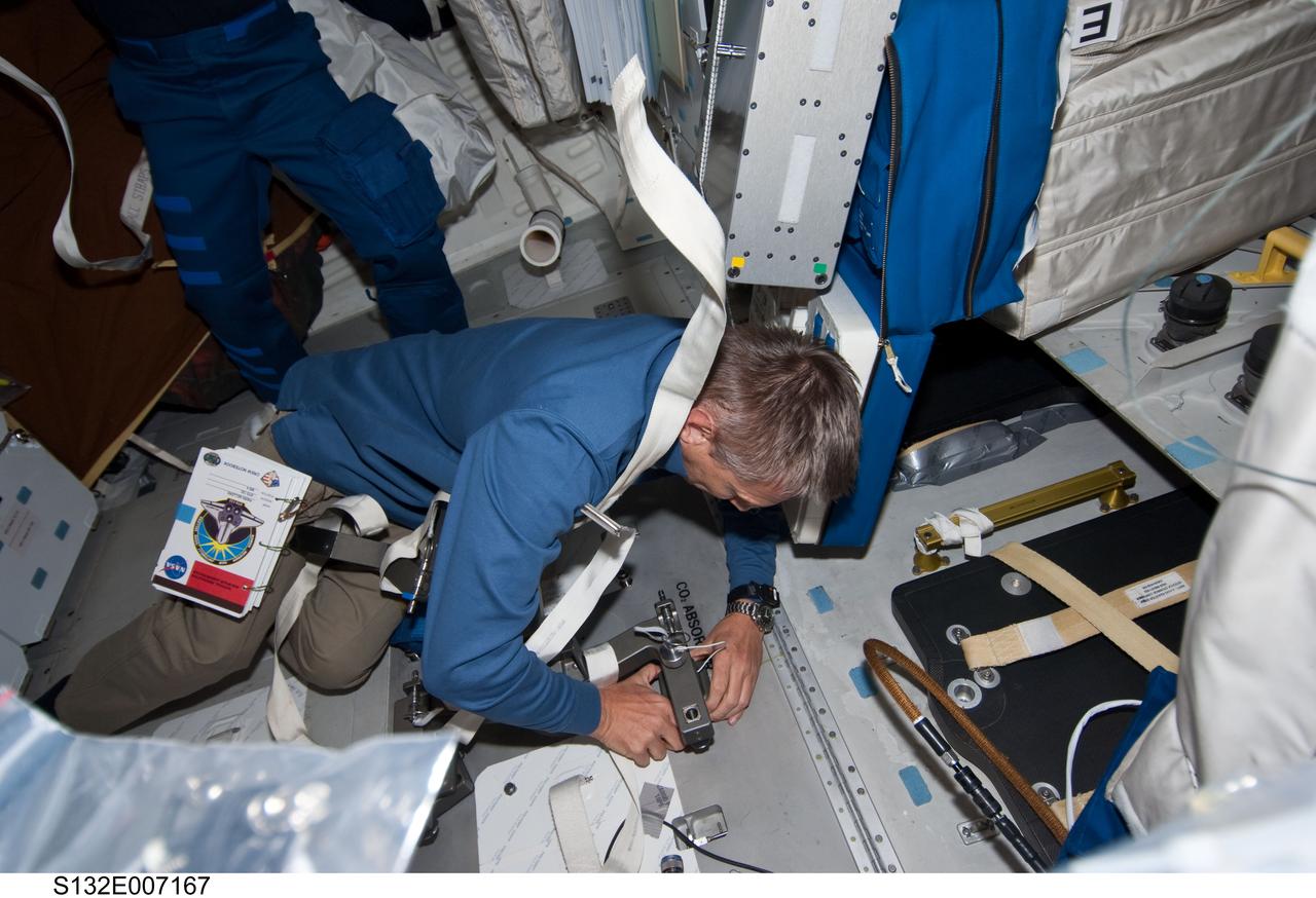 S132-E-007167 (15 May 2010) --- NASA astronaut Piers Sellers, STS-132 mission specialist,  works at the Carbon Dioxide absorber panel door on the middeck of the Earth-orbiting space shuttle Atlantis during Flight Day 2 activities.  Photo credit: NASA or National Aeronautics and Space Administration