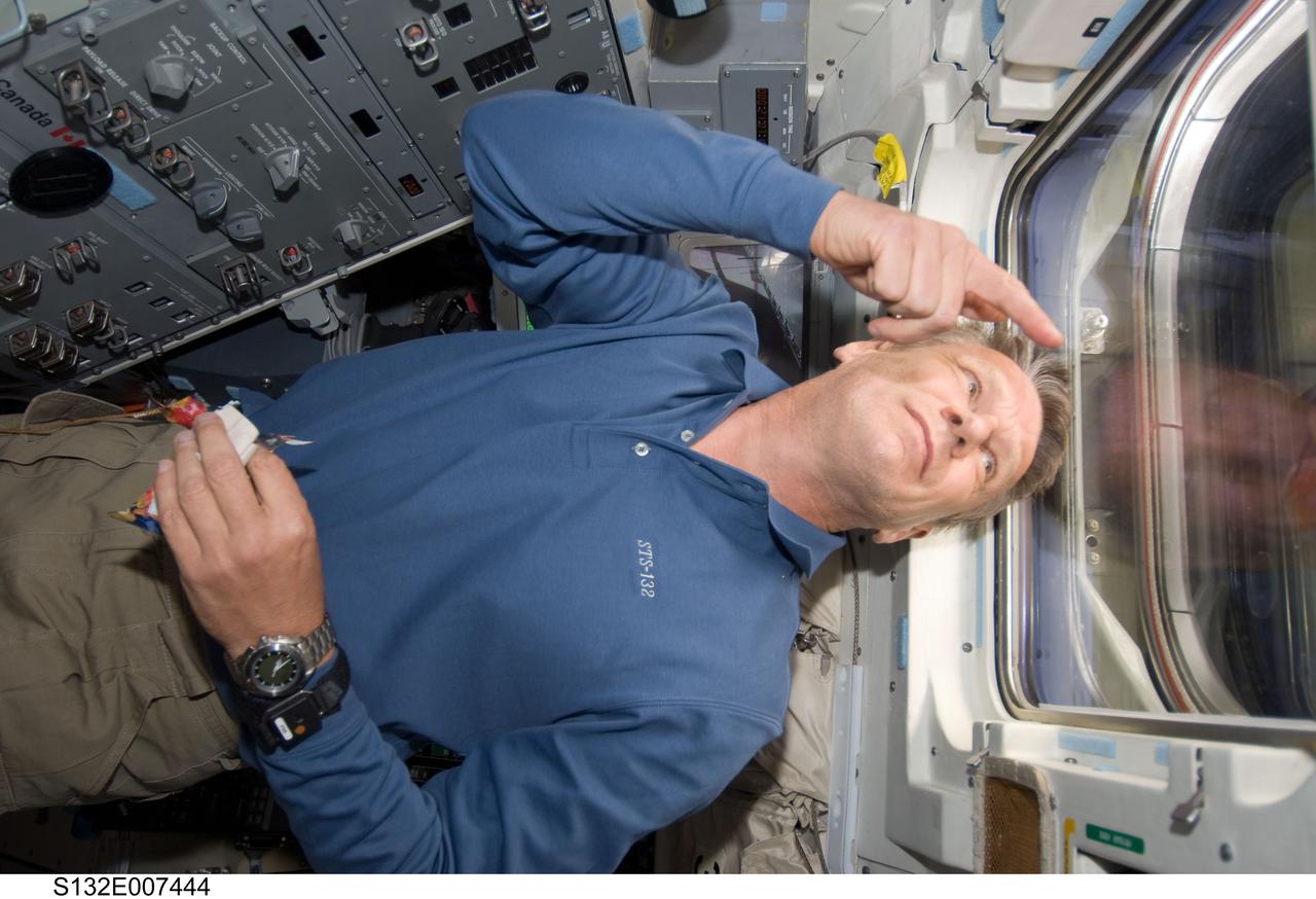 S132-E-007444 (15 May 2010) --- NASA astronaut Piers Sellers, STS-132 mission specialist, looks through an overhead window on the aft flight deck of the Earth-orbiting space shuttle Atlantis during flight day two activities.