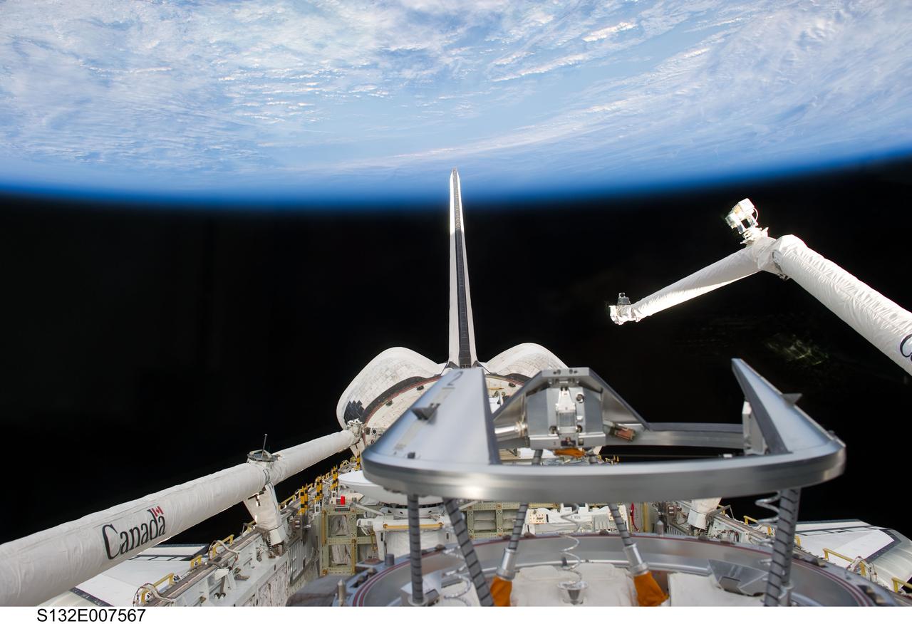S132-E-007567 (15 May 2010) --- Backdropped by Earth’s horizon and the blackness of space, space shuttle Atlantis’ payload bay, docking mechanism (foreground), vertical stabilizer, orbital maneuvering system (OMS) pods, and Remote Manipulator System/Orbiter Boom Sensor System (RMS/OBSS) are featured in this image photographed by an STS-132 crew member from an aft flight deck window.