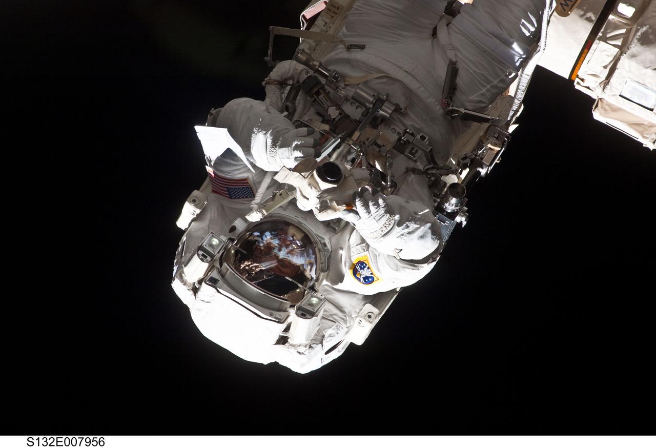 S132-E-007956 (17 May 2010) --- Anchored to a Canadarm2 mobile foot restraint, NASA astronaut Garrett Reisman, STS-132 mission specialist, participates in the mission's first session of extravehicular activity (EVA) as construction and maintenance continue on the International Space Station. During the seven-hour, 25-minute spacewalk, Reisman and NASA astronaut Steve Bowen (out of frame), mission specialist, loosened bolts holding six replacement batteries, installed a second antenna for high-speed Ku-band transmissions and adding a spare parts platform to Dextre, a two-armed extension for the station’s robotic arm.