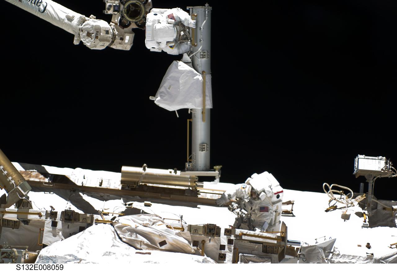 S132-E-008059 (17 May 2010) --- NASA astronauts Steve Bowen (bottom) and Garrett Reisman, both STS-132 mission specialists, participate in the mission's first session of extravehicular activity (EVA) as construction and maintenance continue on the International Space Station. During the seven-hour, 25-minute spacewalk, Bowen and Reisman loosened bolts holding six replacement batteries, installed a second antenna for high-speed Ku-band transmissions and adding a spare parts platform to Dextre, a two-armed extension for the station’s robotic arm.