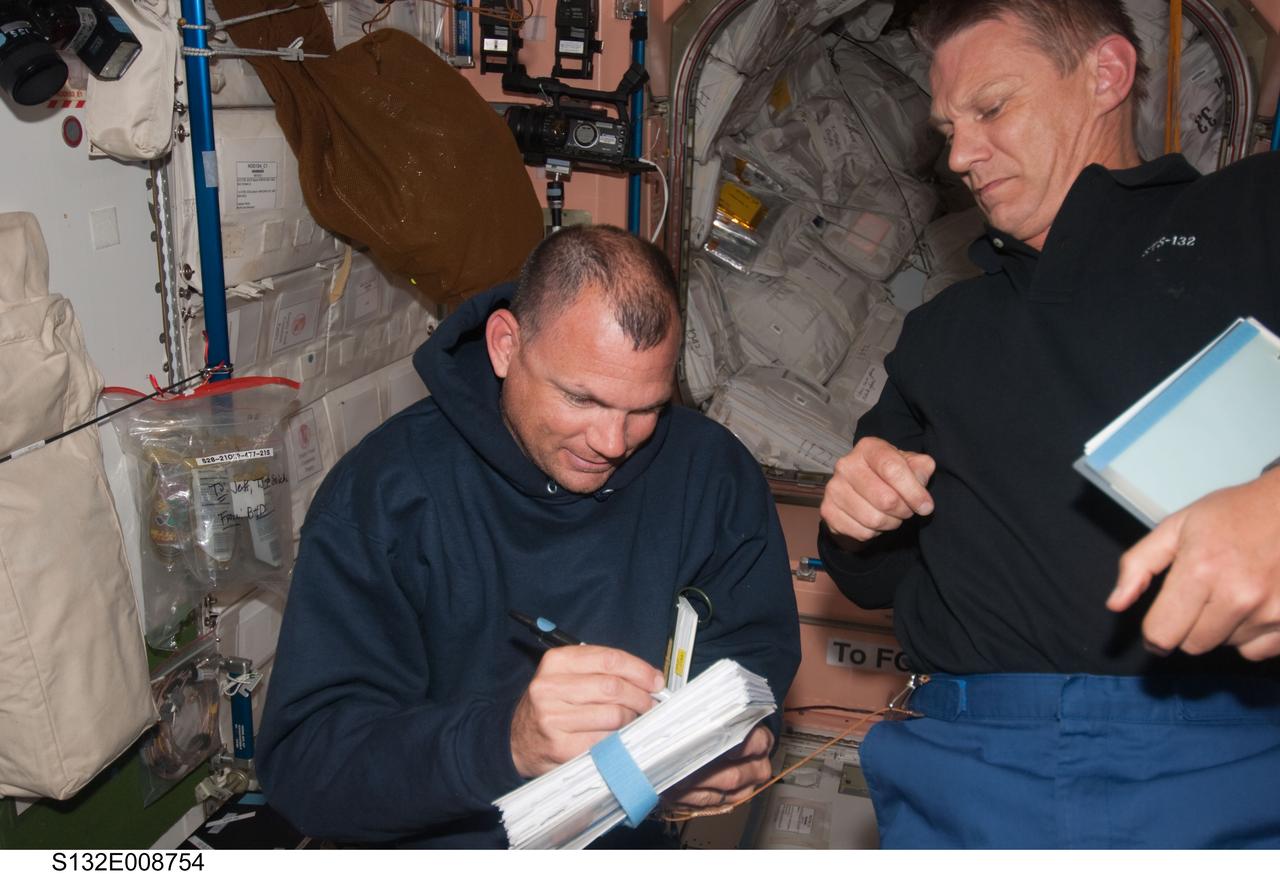S132-E-008754 (20 May 2010) --- NASA astronauts Tony Antonelli (left), STS-132 pilot, and Piers Sellers, mission specialist, work in the Unity node of the International Space Station while space shuttle Atlantis remains docked with the station.