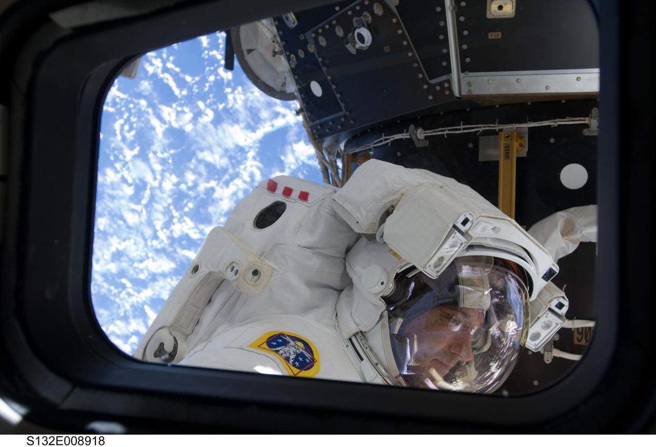 S132-E-008918 (21 May 2010) --- NASA astronaut Michael Good, STS-132 mission specialist, is pictured in the shuttle's forward cargo bay during the flight's final space walk. The photograph was made through one of Atlantis' aft flight deck windows. Crewmate Garrett Reisman (out of frame) joined Good for the May 21 space walk. Photo credit: NASA or National Aeronautics and Space Administration