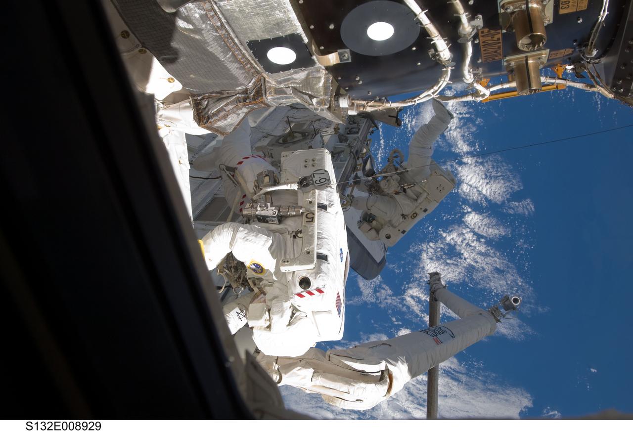S132-E-008929 (21 May 2010) --- NASA astronaut Michael Good, STS-132 mission specialist, is seen in near foreground during the flight's final space walk. The photograph was made through one of Atlantis' aft flight deck windows. NASA astronaut Garrett Reisman can be seen in the background. Photo credit: NASA or National Aeronautics and Space Administration