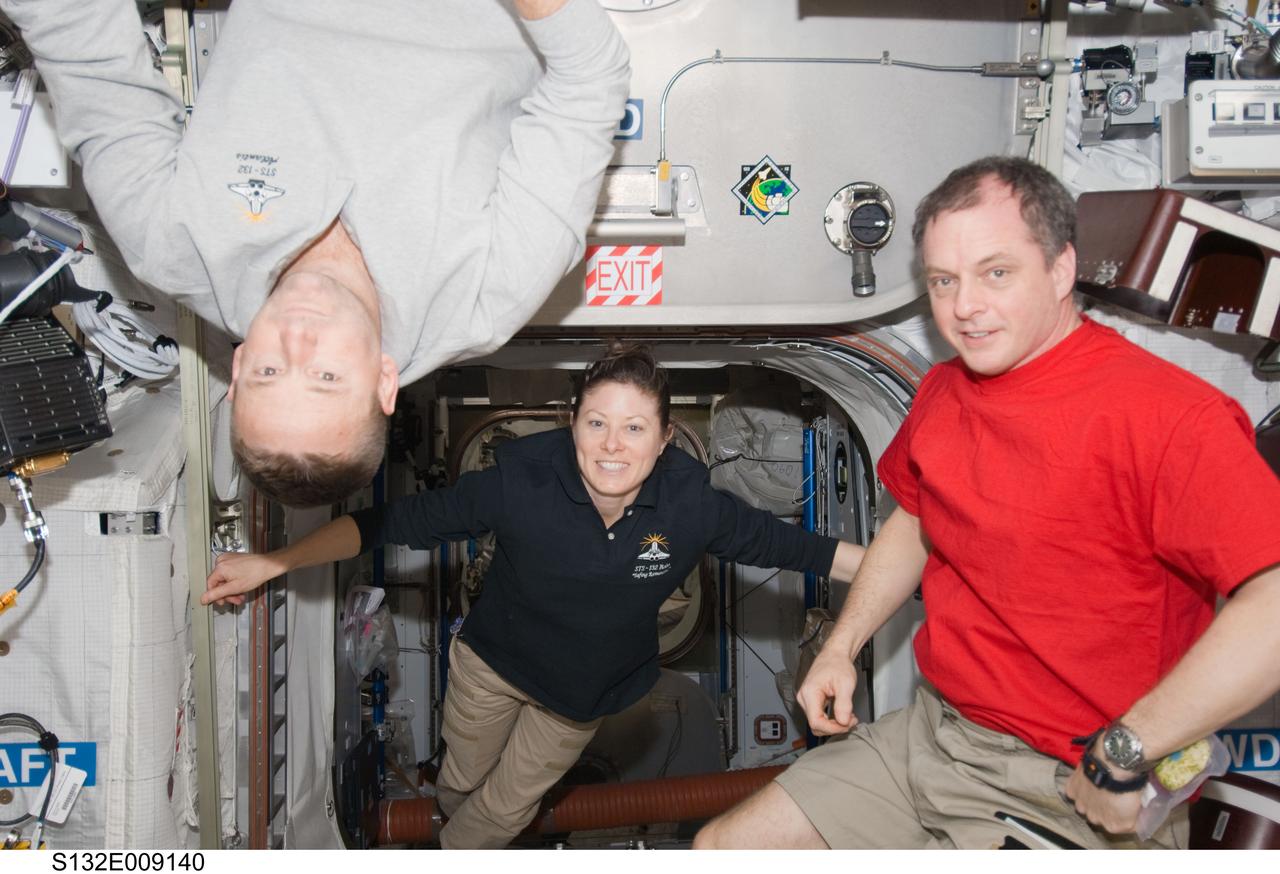 S132-E-009140 (22 May 2010) --- This is not a scene one would likely confront on Earth, with people hanging from the ceiling and floating through the room, but with the existence of a weightless environment, it is commonplace on the International Space Station. The “ceiling hanger” in this scene, NASA astronaut Ken Ham, will lead his six member STS-132 crew off the station May 23, and among those to whom he will be saying goodbye are pictured NASA astronauts Tracy Caldwell Dyson and T.J. Creamer, both flight engineers for the Expedition 23 crew. Photo credit: NASA or National Aeronautics and Space Administration