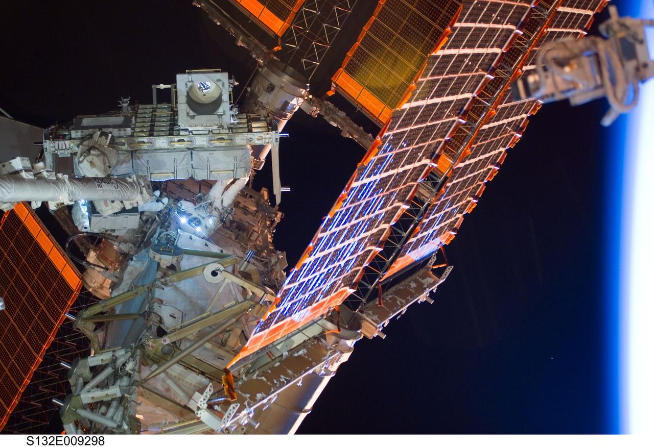 S132-E-009298 (21 May 2010) --- NASA astronauts Michael Good (partially obscured at left) and Garrett Reisman, both STS-132 mission specialists, participate in the mission’s third and final session of extravehicular activity (EVA) as construction and maintenance continue on the International Space Station. During the six-hour, 46-minute spacewalk, Good and Reisman completed the installation of the final two of the six new batteries for the B side of the port 6 solar array. In addition, the astronauts installed a backup ammonia jumper cable between the port 4 and 5 trusses of the station, transferred a Power and Data Grapple Fixture from the shuttle to the station, and reconfigured some tools.