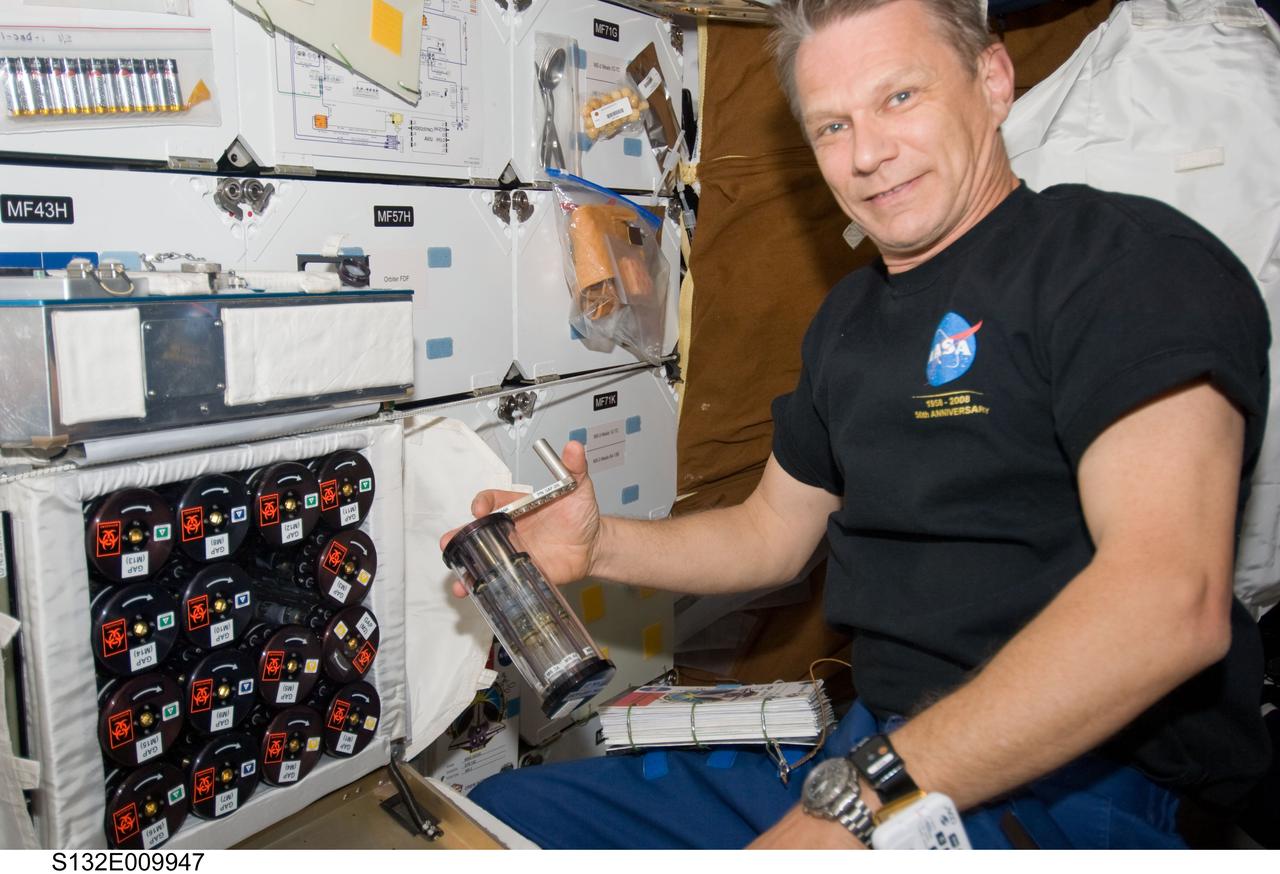 S132-E-009947 (22 May 2010) --- NASA astronaut Piers Sellers, STS-132 mission specialist, works with Group Activation Packs (GAP) on the middeck of space shuttle Atlantis while docked with the International Space Station.
