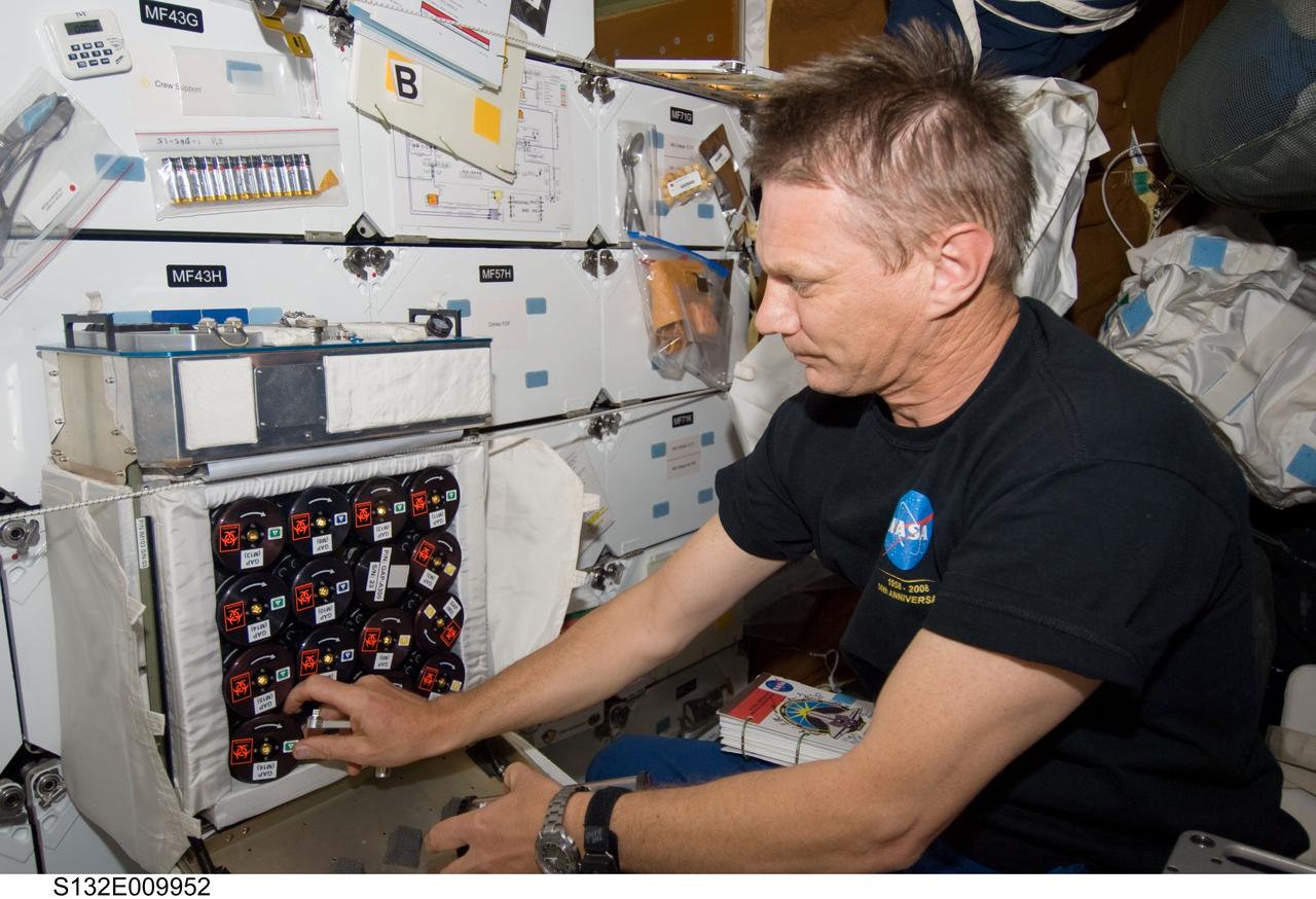 S132-E-009952 (22 May 2010) --- NASA astronaut Piers Sellers, STS-132 mission specialist, works with Group Activation Packs (GAP) on the middeck of space shuttle Atlantis while docked with the International Space Station.