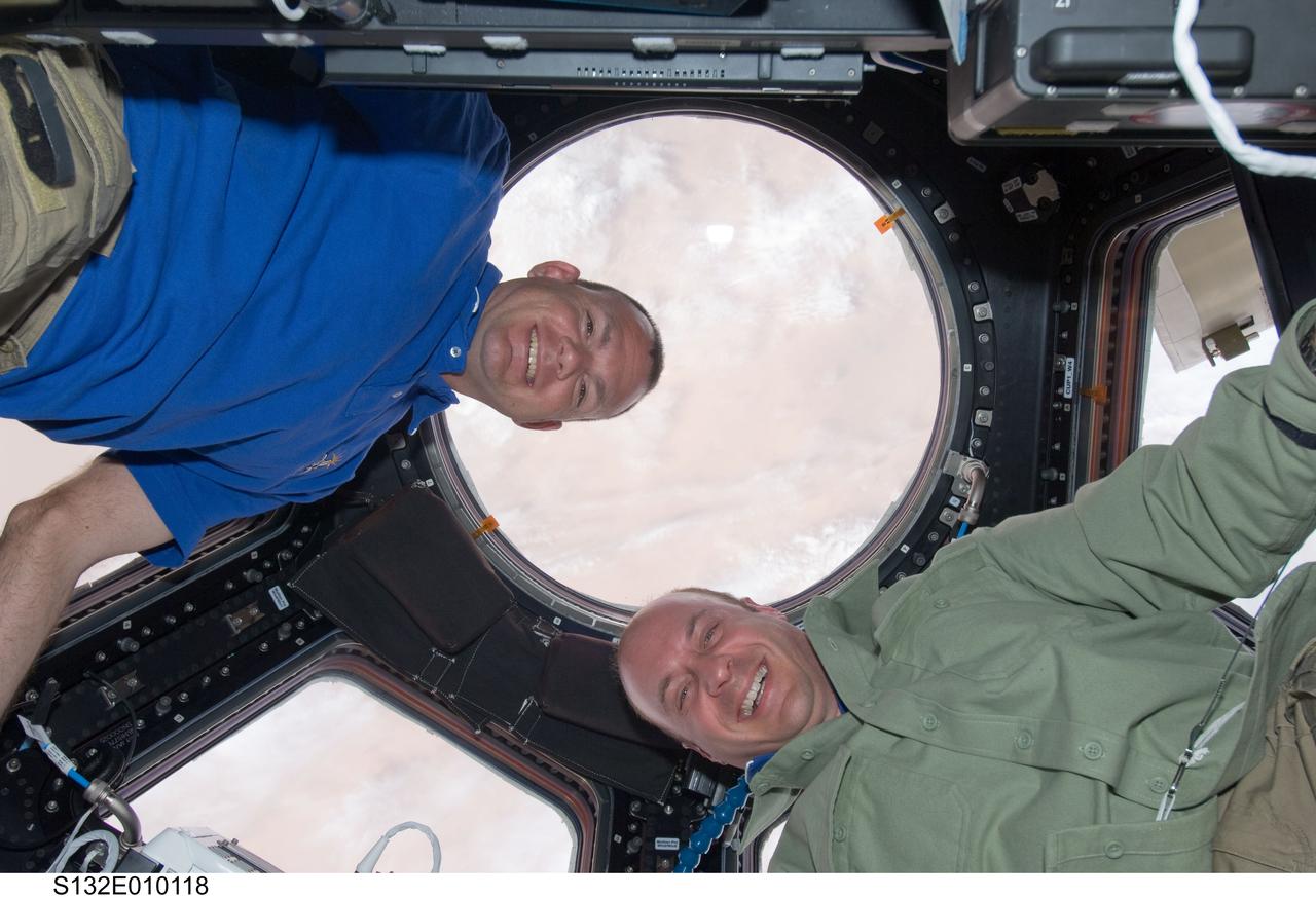 S132-E-010118 (23 May 2010) --- NASA astronauts Tony Antonelli (left), STS-132 pilot; and Garrett Reisman, mission specialist, pose for a photo in the Cupola of the International Space Station while space shuttle Atlantis remains docked with the station.