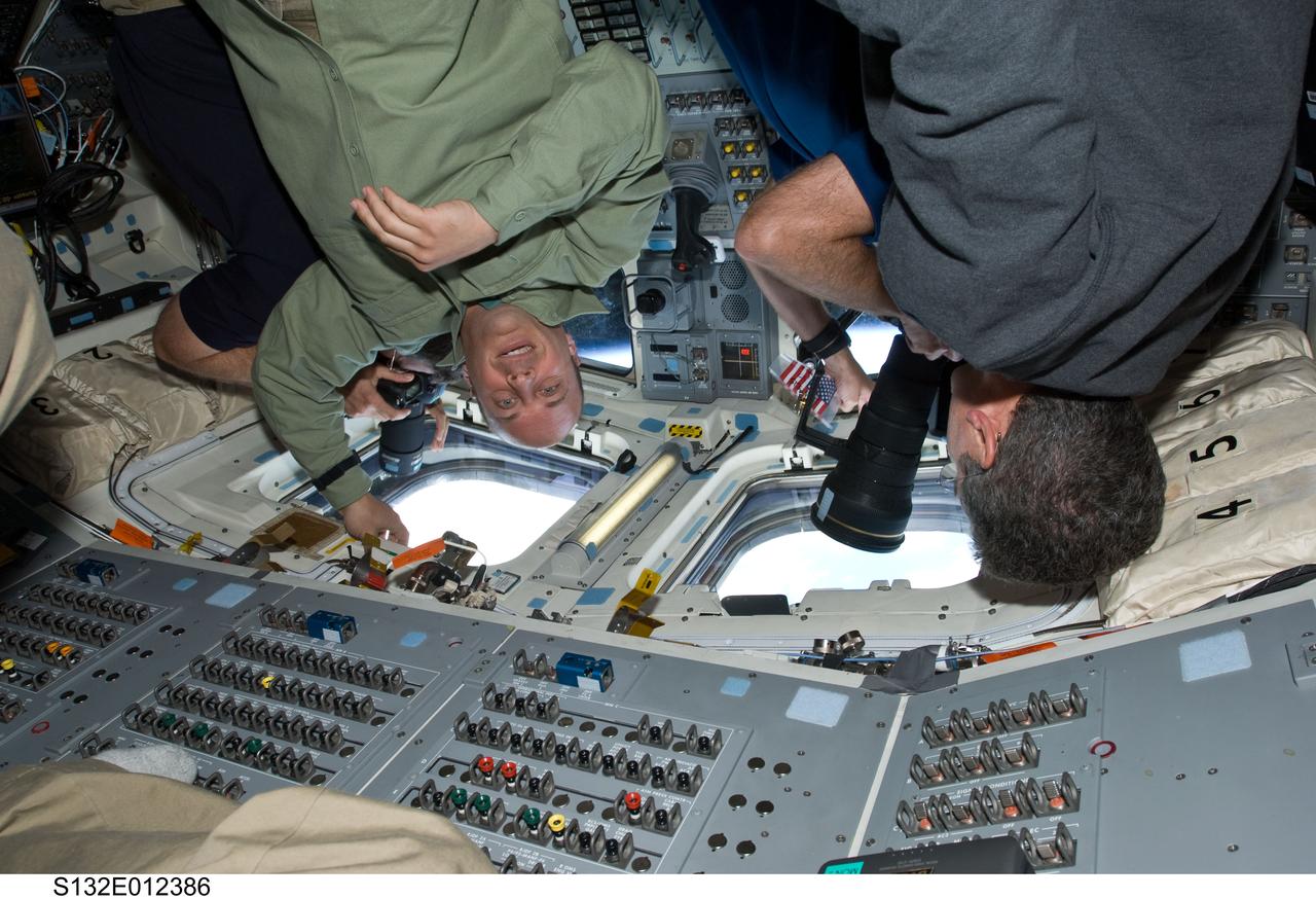 S132-E-012386 (24 May 2010) --- NASA astronauts Garrett Reisman (left) and Michael Good, both STS-132 mission specialists, are pictured on the aft flight deck of space shuttle Atlantis during flight day 11 activities.