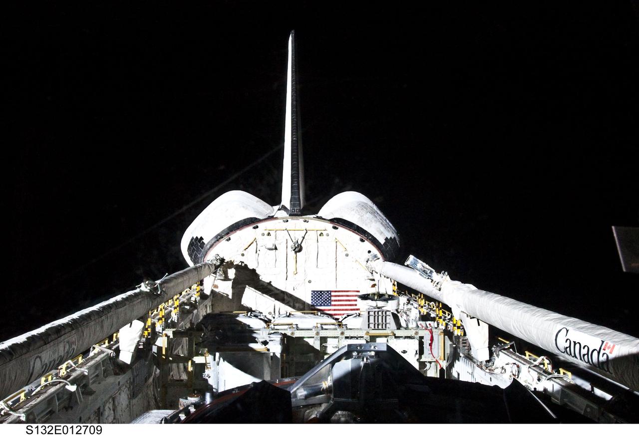 S132-E-012709 (25 May 2010) --- Space shuttle Atlantis’ vertical stabilizer, orbital maneuvering system (OMS) pods, remote manipulator system/orbiter boom sensor system (RMS/OBSS), payload bay and docking mechanism are featured in this image photographed by an STS-132 crew member on the shuttle during flight day 12 activities.