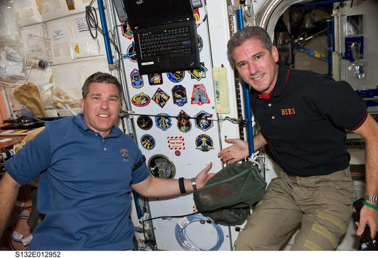 S132-E-012952 (22 May 2010) --- NASA astronauts Steve Bowen (left) and Michael Good, STS-132 mission specialists, pose for a photo after adding the STS-132 patch to the growing collection, in the Unity node, of insignias representing crews who have worked on the International Space Station.