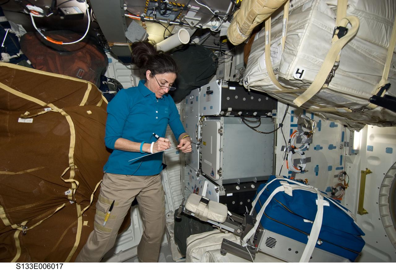 S133-E-006017 (25 Feb. 2011) --- Astronaut  Nicole Stott, mission specialist, keeps stock of where things are during flight day 2 duties on Discovery's middeck. Making its final flight, Discovery and its six person crew are headed toward a rendezvous with the International Space Station. Photo credit: NASA or National Aeronautics and Space Administration