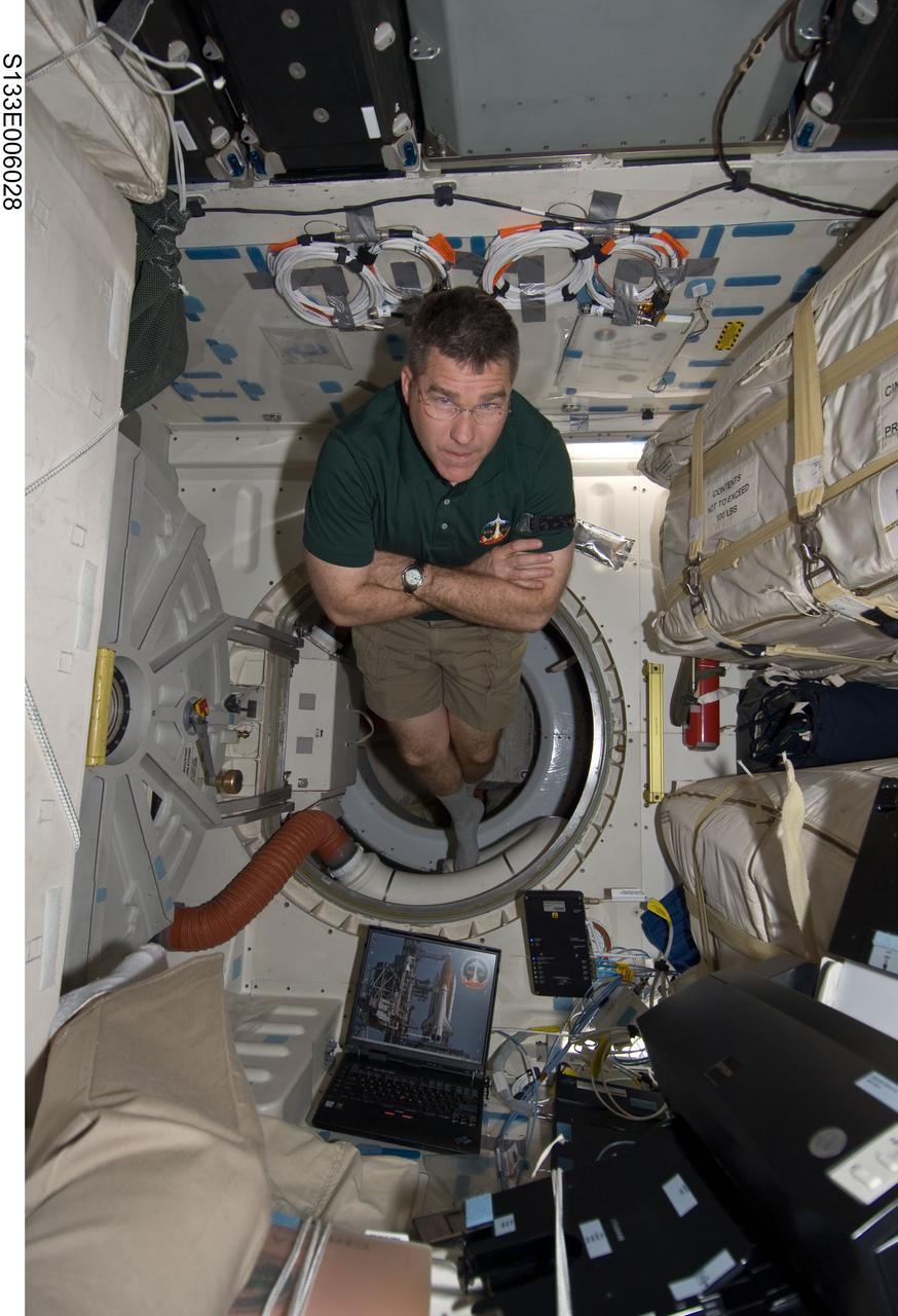 S133-E-006028 (25 Feb. 2011) --- Near space shuttle Discovery's airlock, astronaut Steve Bowen, STS-133 mission specialist, hovers momentarily on the middeck. Perhaps he is thinking about next week's extravehicular activity (EVA) on the International Space Station to which he has been assigned as a replacement for an original prime crew member who was injured in an accident weeks prior to the shuttle's scheduled launch. Photo credit: NASA or National Aeronautics and Space Administration