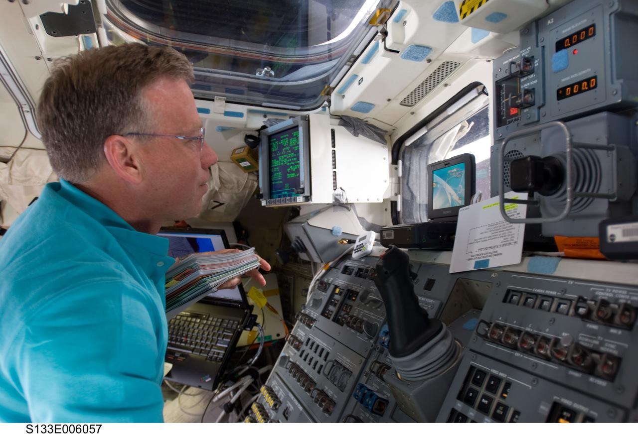 S133-E-006057 (25 Feb. 2011) --- On space shuttle Discovery’s aft flight deck, astronaut Steve Lindsey, STS-133 commander, utilizes in- cabin controls to help conduct thorough inspections of the shuttle’s thermal tile system with the aid of the Remote Manipulator System/Orbiter Boom Sensor System (RMS/OBSS) and special cameras. Photo credit: NASA or National Aeronautics and Space Administration