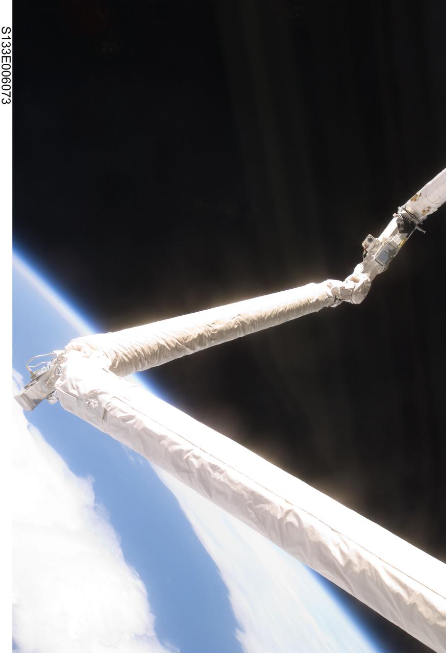 S133-E-006073 (25 Feb. 2011) --- Controlled by the STS-133 astronauts inside Discovery's cabin, the Remote Manipulator System/Orbiter Boom Sensor System (RMS/OBSS) equipped with special cameras, begins to conduct thorough inspections of the shuttle’s thermal tile system on flight day 2. Photo credit: NASA or National Aeronautics and Space Administration