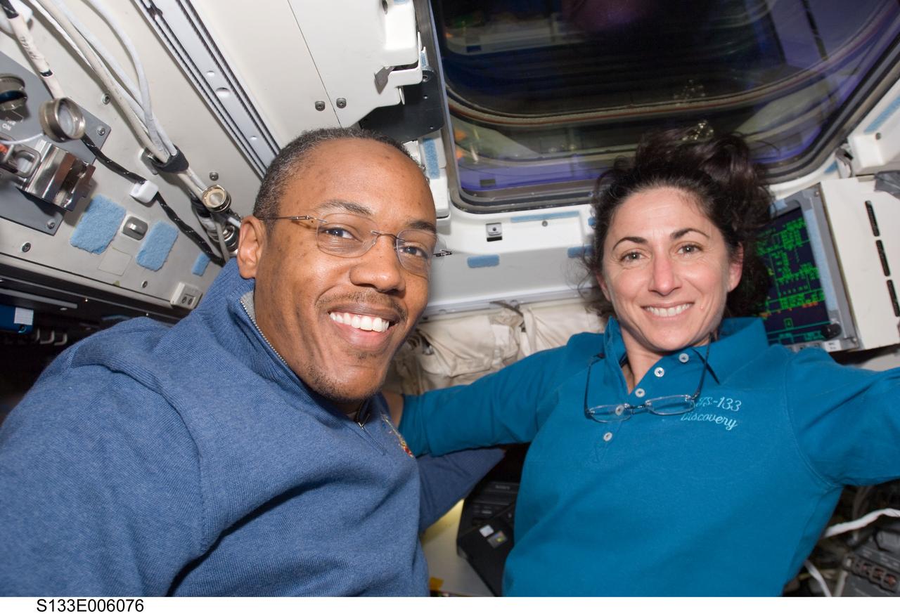 S133-E-006076 (25 Feb. 2011) --- Astronauts  Alvin Drew and Nicole Stott, both STS-133 mission specialists, take a break from flight day 2 duties on Discovery's aft flight deck as the shuttle makes its way toward a weekend docking with the International Space Station. Photo credit: NASA or National Aeronautics and Space Administration