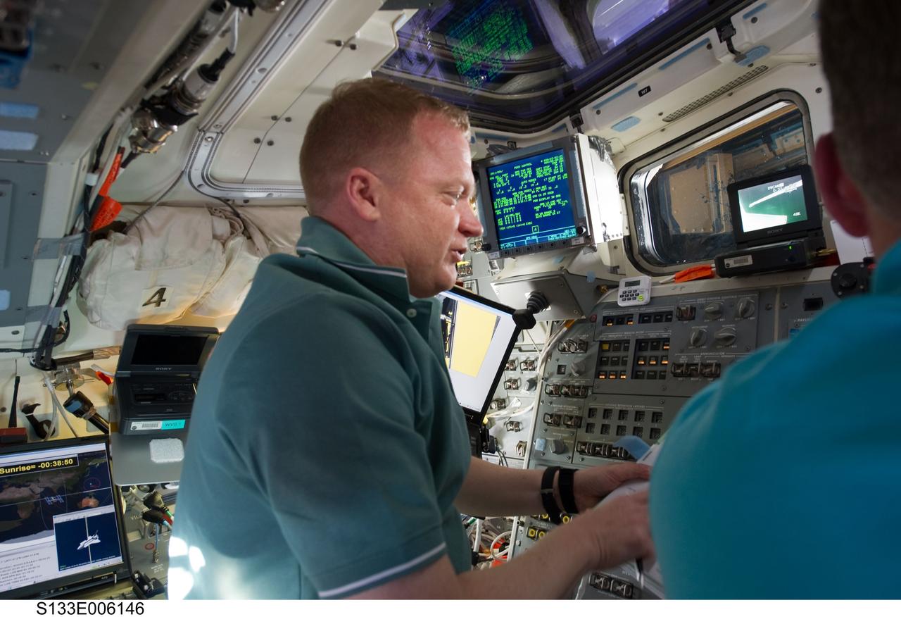 S133-E-006146 (25 Feb. 2011) --- NASA astronaut Eric Boe, STS-133 pilot, works on the aft flight deck of space shuttle Discovery during flight day two activities. Photo credit: NASA or National Aeronautics and Space Administration