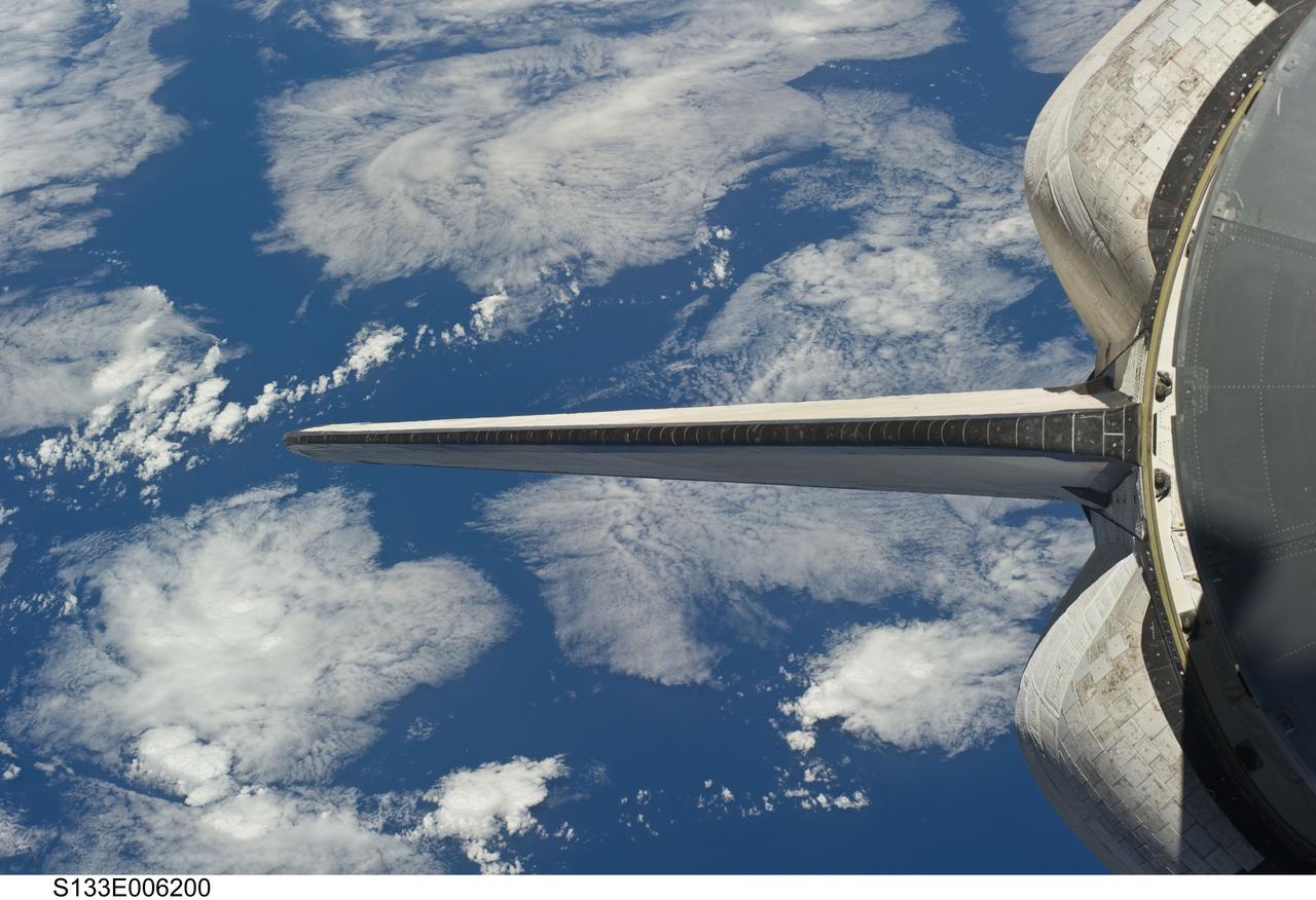 S133-E-006200 (25 Feb. 2011) --- Backdropped by a blue and white part of Earth, space shuttle Discovery’s vertical stabilizer and orbital maneuvering system (OMS) pods are featured in this image photographed by an STS-133 crew member during flight day two activities. Photo credit: NASA or National Aeronautics and Space Administration